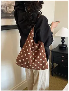Detail view of the brown suede polka dot shoulder tote bag in a cozy retro room setting.