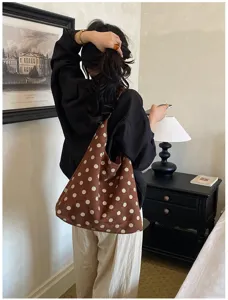 Detailed lifestyle view of the brown polka dot suede shoulder bag showcasing fabric texture.