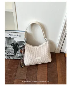 Vue détaillée du sac porté épaule beige tissé chic avec une élégante ambiance rétro.