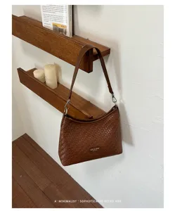 Détail de sac bandoulière tissé marron affichant une texture élégante et un style rétro.