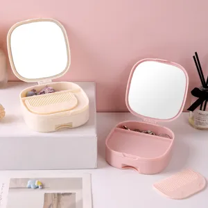 Multifunctional makeup mirror jewelry storage box with folding vanity mirror and comb.