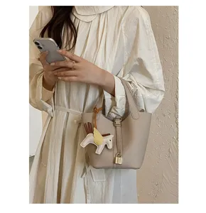 Detailed shot of a trendy leather bucket handbag with padlock and cute winged horse charm.