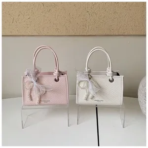 Kleine dames handtas met parel strik, trendy PU lederen crossbody schoudertas detail.