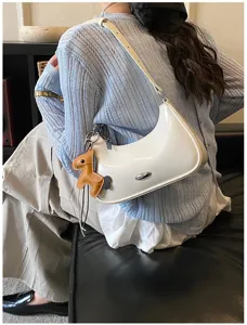 Elegante borsa a spalla bianca in pelle verniciata con ciondolo cavallo per uso quotidiano.