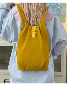 Vue détaillée du sac à dos jaune léger style gilet, montrant les bretelles et la texture du tissu.