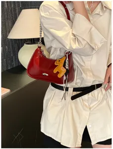 Elegante borsa a spalla rossa in vernice con catena e ciondolo a cavallo per donne.