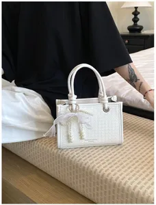 Witte geweven mini shopper tas met zeer elegante parel en strik hanger voor dames.