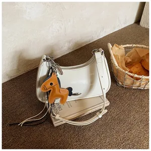 Borsa a spalla chic in pelle verniciata bianca con ciondolo a cavallo e tracolla.
