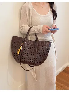 Detail view of the brown woven cutout tote bag, showcasing large capacity and retro style.