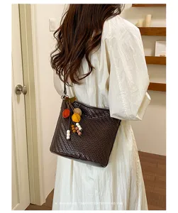 Detailed view of the dark brown retro woven bucket bag with chic charms, elegant style.