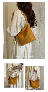 Detailed lifestyle view of the yellow woven shoulder bag showcasing exquisite details.