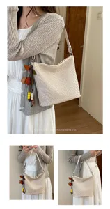 Detailed view of a minimalist retro woven shoulder bag with chic charms, elegant everyday style.