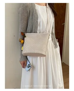 Minimalist woven crossbody bag for women, stylish bucket handbag with chic retro vibe.
