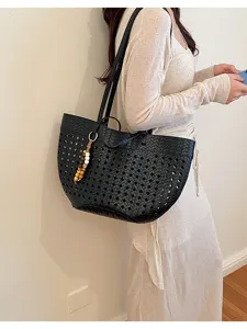 Black woven hollow shoulder tote bag with cute wooden beads charm, casual commuting style.