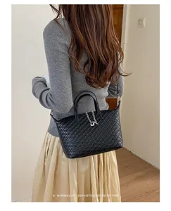 Black woven dumpling bag for women, stylish leather handbag with chain, daily commuter crossbody bag.