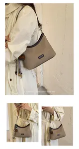 Retro hobo shoulder bag for women, chic PU leather trim with tassel pendant and minimalist style.