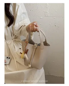 Elegant minimalist leather bucket bag with charming Pegasus pendant for women daily stylish look.