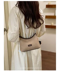 Close-up detail of stylish retro underarm shoulder bag with contrast trim and textured fabric.
