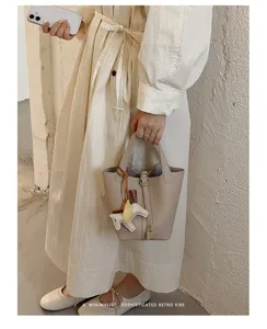 Minimalist chic leather bucket bag with horse charm, elegant handbag for women daily wear.