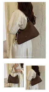 Details of the retro brown hobo shoulder bag showing texture, strap and stylish pendant.