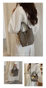 Elegant grey leather bucket bag with top handle and chic charm, perfect for daily style.