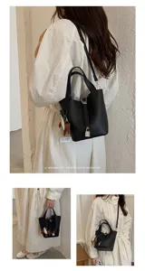 Detailed view of women's black leather bucket handbag with shoulder strap and lock.