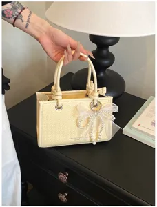 Elegante crèmekleurige geweven handtas met parel strik detail, chique damestas schoudertas.