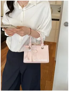 Roze geweven handtas met een elegante witte strik en parels voor modieuze vrouwen.