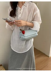 Woven underarm bag for women, trendy leather shoulder crossbody bag with strawberry charm.