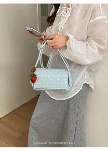 Light blue woven shoulder bag for women, stylish faux leather crossbody bag with cute charm.