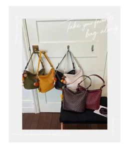 Detailed scene showing retro woven leather shoulder bucket bags in assorted colors.