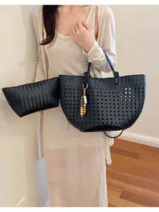 Black woven hollow-out tote bag and matching pouch detail, stylish commuting shoulder bag.