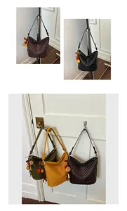 Detailed view of stylish woven bucket shoulder bag featuring chic charm details for daily use.