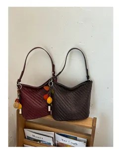 Exquisite woven hobo shoulder bag detail, stylish retro bucket bag with chic charm pendant.