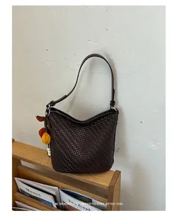 Retro woven leather shoulder bucket bag detail view, chic charms and elegant retro style.