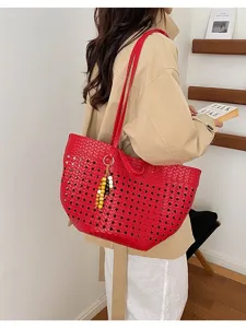 Detailed view of red woven hollow-out tote bag, stylish shoulder bag with beaded charm.