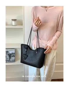Elegante borsa shopper nera in pelle intrecciata da donna, borsa a spalla per la moda autunnale.