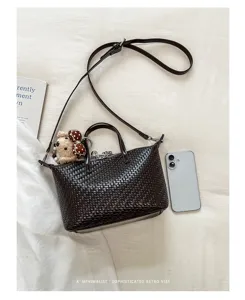 Dark brown woven handbag detail shot, featuring chic crossbody strap and cute pendant.
