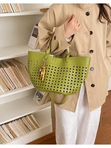 Close-up of the green hollow woven tote bag featuring a unique wooden bead charm detail.