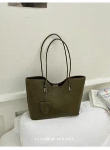 Vista dettagliata della borsa tote con trama intrecciata verde oliva e spallacci.