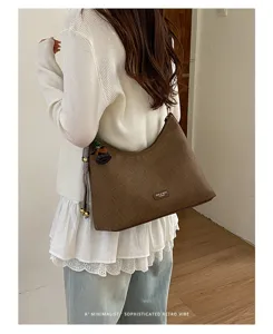 Brown textured hobo shoulder bag detail, minimalist retro style daily commuter handbag.