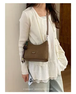 Retro brown hobo shoulder bag for women, chic minimalist crossbody bag with stylish charm accessory.