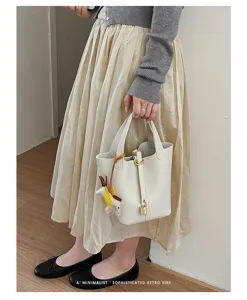 Minimalist PU leather bucket handbag for women, chic portable tote bag with lock charm.
