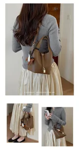 Minimalist brown leather bucket bag with top handle and stylish padlock charm for women.