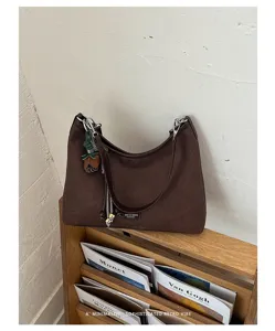 Retro brown shoulder bag detail showcasing minimalist design, spacious interior, and elegant texture.