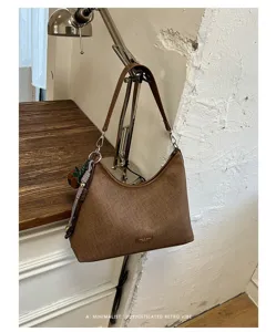 Minimalist retro brown shoulder bag close-up, stylish women hobo bag for autumn vintage aesthetic vibe.