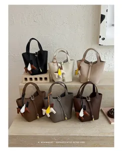 Korean style minimalist leather bucket bag with cute horse charm for stylish women daily use.
