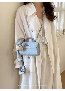Light blue quilted shoulder bag with chain strap and cute bear plush pendant for women.