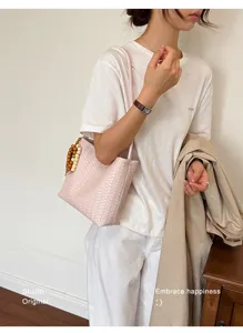 Sac seau en cuir tressé pour femme, élégant sac à ornement de perles en bois pour look chic.