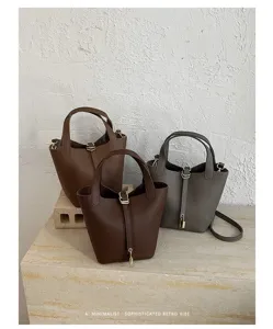 Minimalist retro bucket bag with top handle and secure lock detail, trendy and chic daily.
